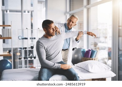 Doctor, man and patient with examination for shoulder pain with physical therapy, stretching or body recovery. Orthopedic, physician or medical expert for arm rehabilitation with healthcare or advice - Powered by Shutterstock