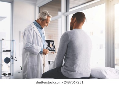 Doctor, man and patient with tablet for xray consultation of spine anatomy, inflammation and surgery planning. Senior radiologist, digital app and happy with health assessment and medical analysis - Powered by Shutterstock