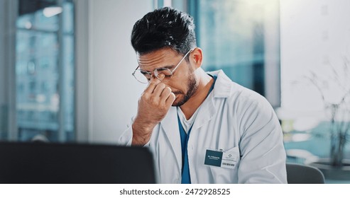 Doctor, man and tired with headache by laptop, anxiety and frustrated in modern office at hospital. Person, pain and stress with migraine, fatigue and burnout with computer for telehealth services - Powered by Shutterstock