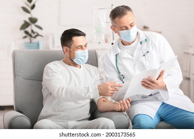 Doctor And Man Undergoing Course Of Chemotherapy In Clinic. Prostate Cancer Awareness Concept