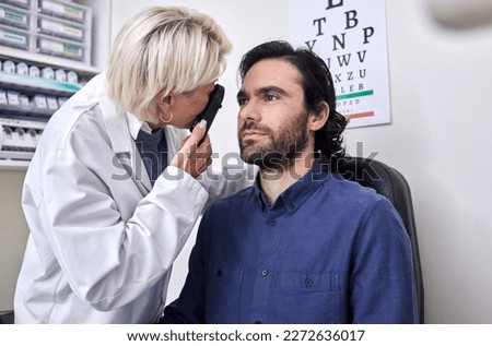 Doctor with a man in a vision test or eye exam for eyesight by doctor, optometrist or ophthalmologist with medical aid. Patient or client with a helpful senior optician to see or check glaucoma