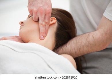 Doctor manipulating the neck of a woman while using his fingertips indoors