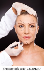 Doctor Marking Senior Woman Face For Plastic Surgery