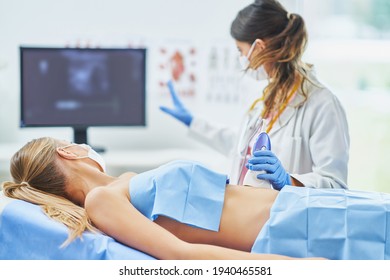 Doctor In Mask Doing Ultrasound Abdomen Test To Female Patient