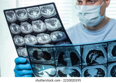 Doctor In Mask Examines And Compares Two MRI Scans.