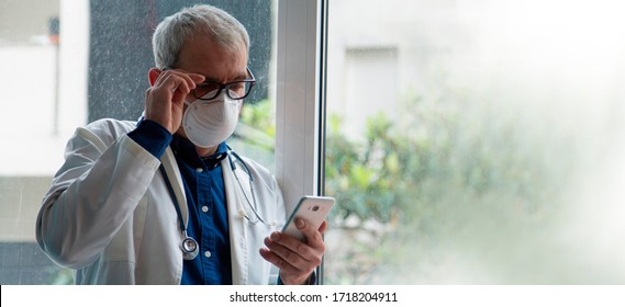 Doctor With Mask Using Mobile Phone