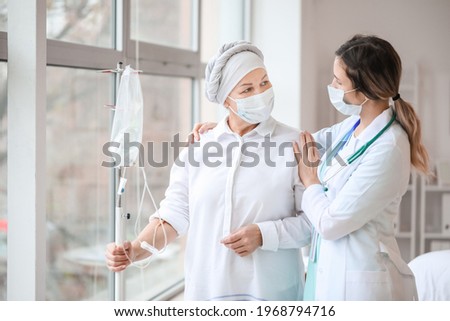 Doctor and mature woman undergoing chemical therapy course in clinic