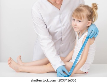 The Doctor Measures The Length Of The Arm Of A Child Of A Girl 4 Years Old. Child Growth Measurement And Anthropometric Data Concept. Copy Space For Text