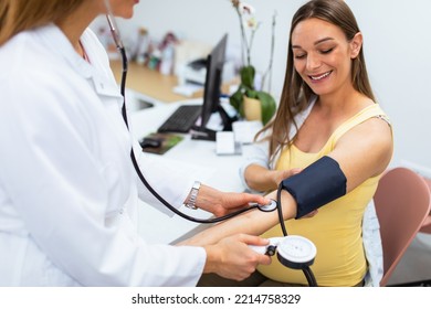 A doctor measures a pregnant woman's blood pressure during a regular check-up.