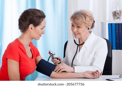 The doctor measures the pressure of a young woman - Powered by Shutterstock