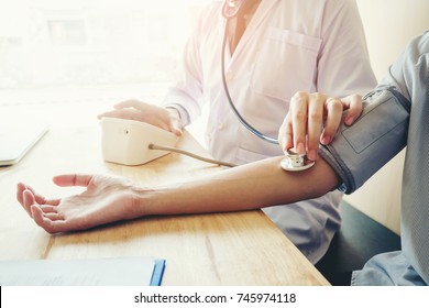 Doctor Measuring arterial blood pressure woman patient on arm Health care in hospital