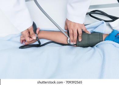 Doctor Measuring Blood Pressure Of Child Patient. With Care