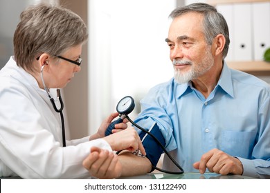 Doctor Measuring Blood Pressure Of Male Patient