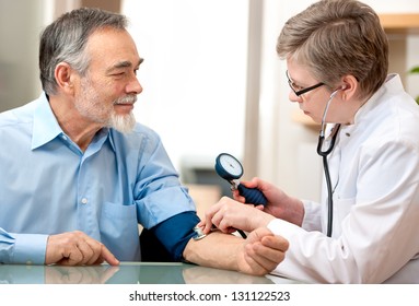 Doctor Measuring Blood Pressure Of Male Patient