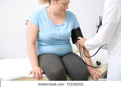 Doctor Measuring Blood Pressure Of Overweight Woman In Hospital