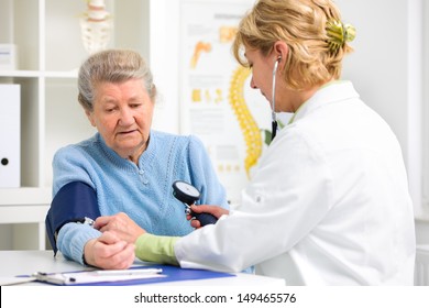 Doctor measuring blood pressure of senior patient