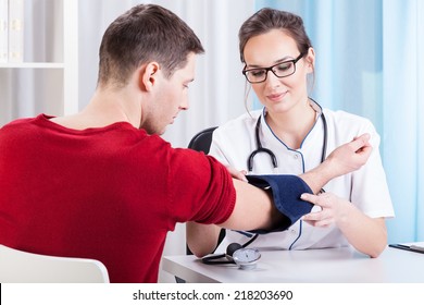 Doctor Measuring Blood Pressure Of Young Man