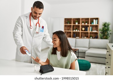 Doctor measuring glucose to latin woman at clinic - Powered by Shutterstock