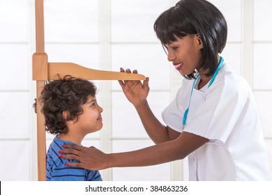 Doctor Measuring Height Of Little Boy On Traditional Medical Scale