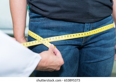 Doctor measuring hip of patients, checking for Body mass index (BMI).