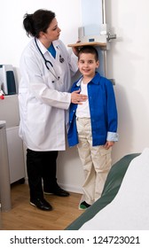 Doctor Measuring Little Child Boy Height Growth At Clinic.