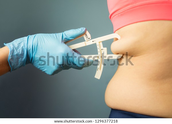 Doctor measuring patient\'s\
body fat