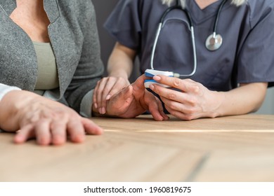 Doctor Measuring Patients Hemoglobin Level. Showing Usage Of Finger Pulse Oximeter