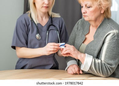 Doctor Measuring Patients Hemoglobin Level. Showing Usage Of Finger Pulse Oximeter