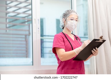 Doctor Medical Checking Information Consulting Patient For Outbreak COVID-19 Epidemic Virus Outbreak Concept . Medical Staff In Face Shield And Medical Mask For Prevention Of Coronavirus Pandemic .