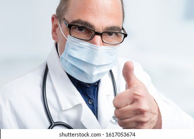 Doctor With Medical Face Mask And Stethoscope Shows Thumbs Up