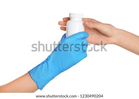 Doctor in medical glove giving bottle of pills to patient on white background
