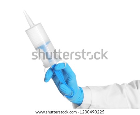 Doctor in medical glove holding large syringe on white background