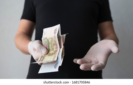 A Doctor In Medical Gloves Holds Russian Rubles. Very Little Money, The Concept Of Bribery And Corruption