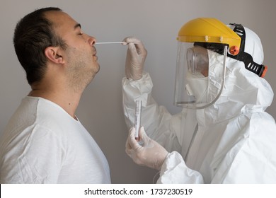 Doctor With Medical Jumpsuit Examing PCR / Corona / Covid19 Test To A Male Patient