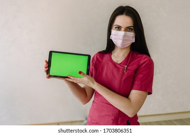 Doctor In Medical Mask Holding Tablet. Green Screen