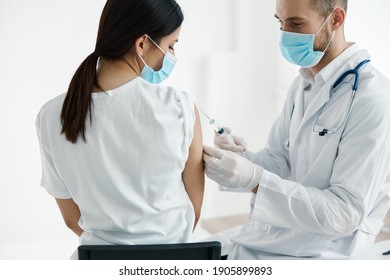 doctor in medical mask injecting vaccine on woman's shoulder epidemic hospital