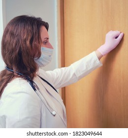 Doctor In Medical Mask Knocks On The Door Of The House