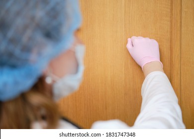 Doctor In Medical Mask Knocks On The Wooden Door