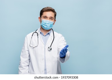 Doctor In Medical Mask And White Coat With Stethoscope Pointing With Hand Isolated On Blue