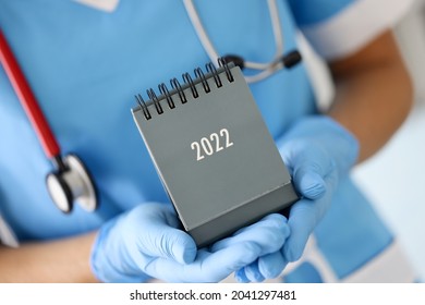 Doctor In Medical Rubber Gloves Holding Desk Calendar For 2022 Closeup