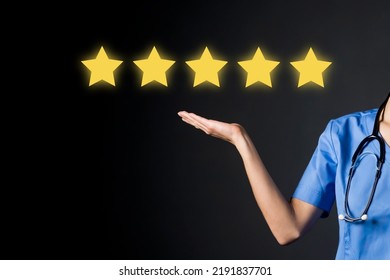 A doctor in a medical suit shows with her hand five stars, the service rating in the clinic, the trust of patients and the competence. A woman medic with a rate of the quality of treatment. - Shutterstock ID 2191837701