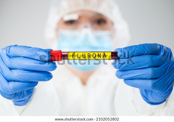 Doctor medical worker holding test tube specimen holder\
containing patient blood sample,SARS-CoV-2 FLURONA variant\
concept,new Coronavirus flu mutation causing new COVID-19 pandemic\
cases worldwide 