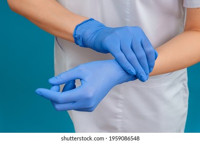 The doctor or medical worker puts on sterile disposable gloves. Hands wearing blue gloves. Medical and surgical gloves. Healthcare and medical concept. - Powered by Shutterstock