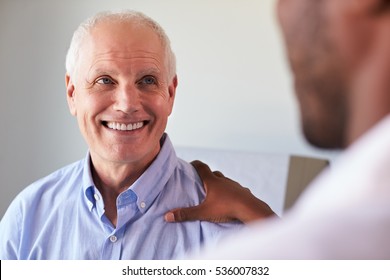 Doctor Meeting With Mature Male Patient In Exam Room