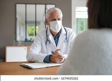 Doctor meeting with patient, wearing protection mask
