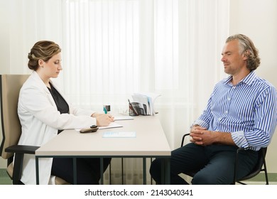 Doctor And Middle Aged Male Patient During Consultation In Office