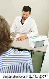 Doctor And Middle Aged Male Patient During Consultation In Office