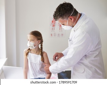 Doctor with mouth mask gives injection to girl with mouth mask