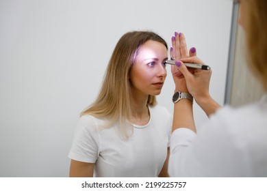 Doctor Neurologist Shining Flashlight On Patient Eyes To See Pupil Reaction To Light In Clinic