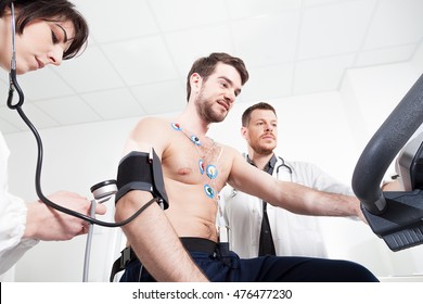 Doctor and nurse assist the patient during the medical examination of cardiac stress test